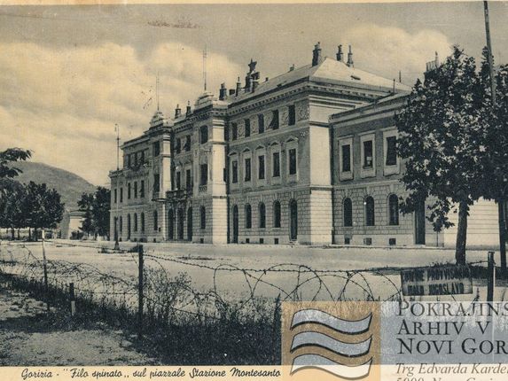 . Železniška postaja kmalu po razmejitvi leta 1947, bodeča žica teče po novi meji med Italijo in Jugoslavijo.  &copy;Postcard from the collection of Regional Archive in Nova Gorica (Pokrajinski arhiv v Novi Gorici). PANG 0667 Nova Gorica: železniška postaja, meja [razglednica]